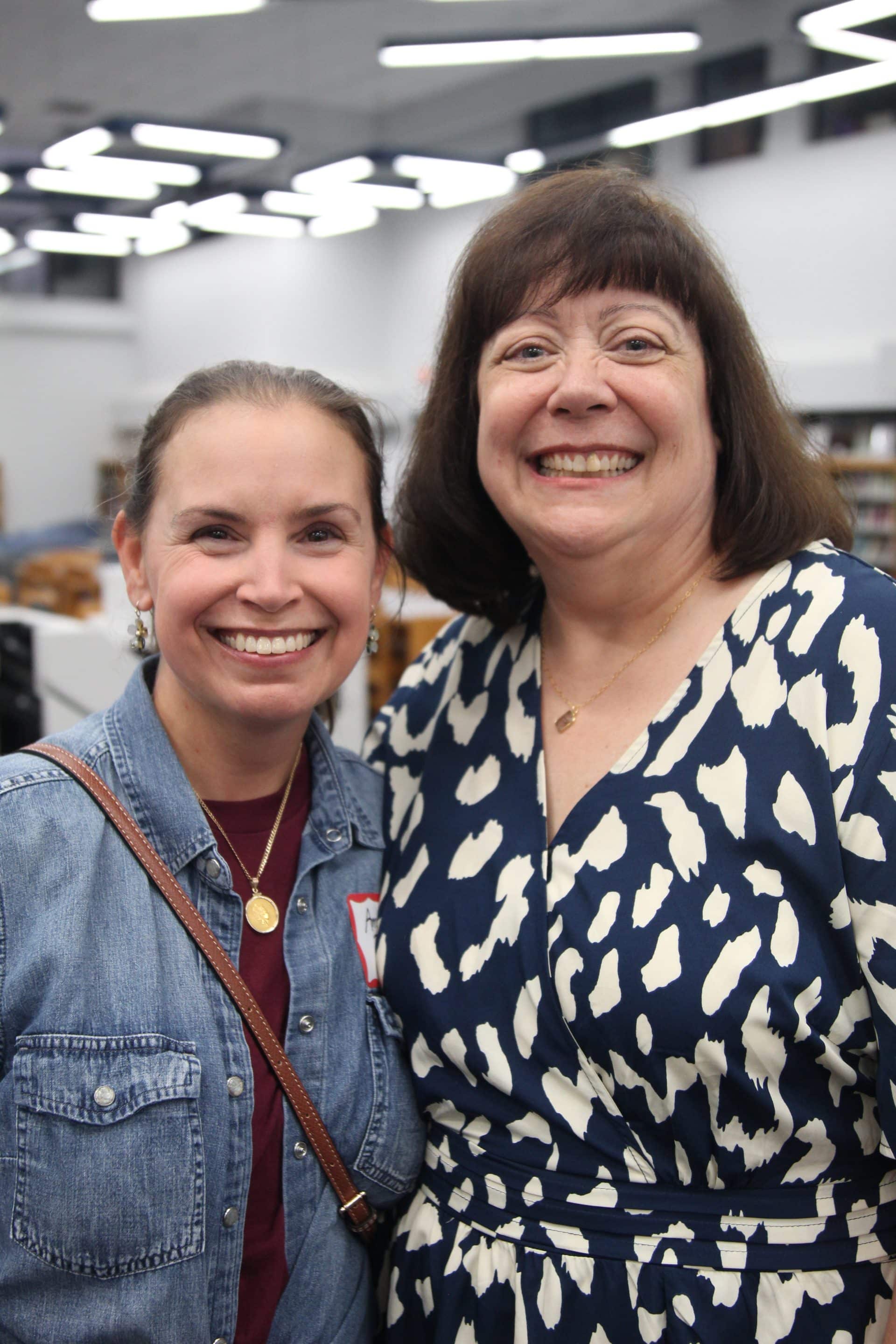 A teacher named Melissa Reynolds in a red shirt working with a student in a red jacket and a computer.